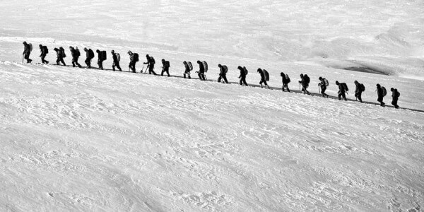 line of backpackers in the snow